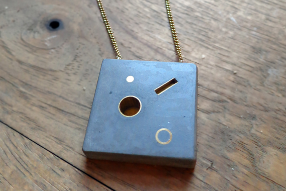 Cast concrete pendent with bronze inlay. Bronze chain.